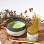 Matcha green tea bowl with Suma matcha canister on a wooden surface