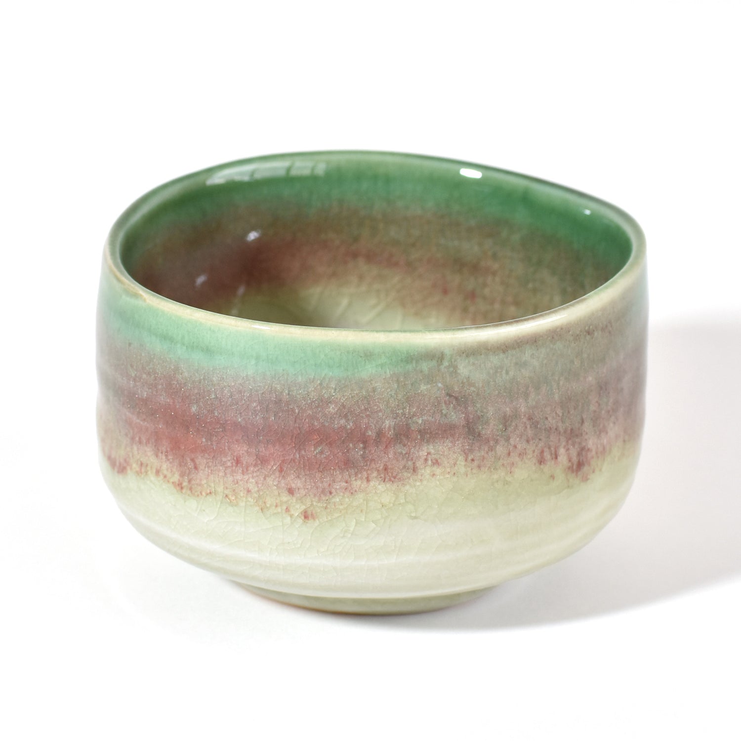 Ceramic matcha bowl with green and brown gradient on a white background