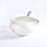 White ceramic bowl with pink floral patterns on a white background