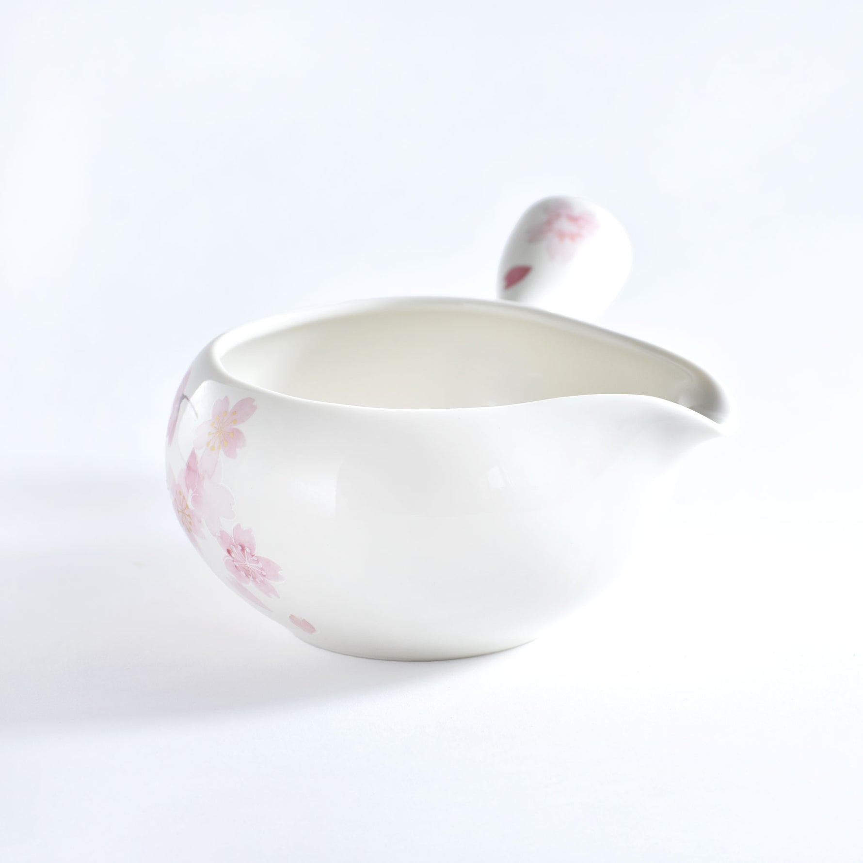 White ceramic bowl with pink floral patterns on a white background
