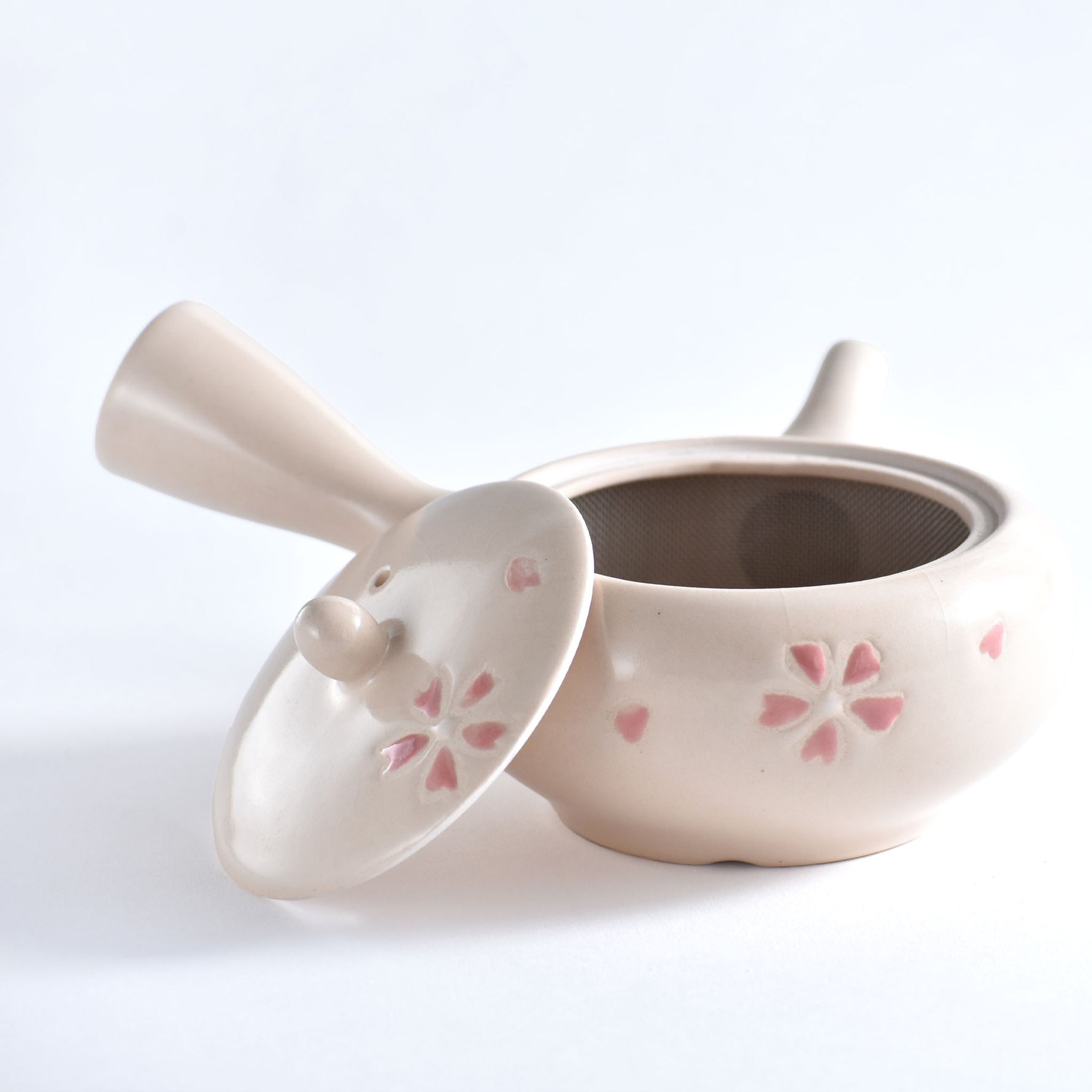 Ceramic teapot with floral designs on a white background