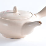 White ceramic teapot with a lid on a white background