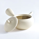White ceramic pot with lid on a light gray background
