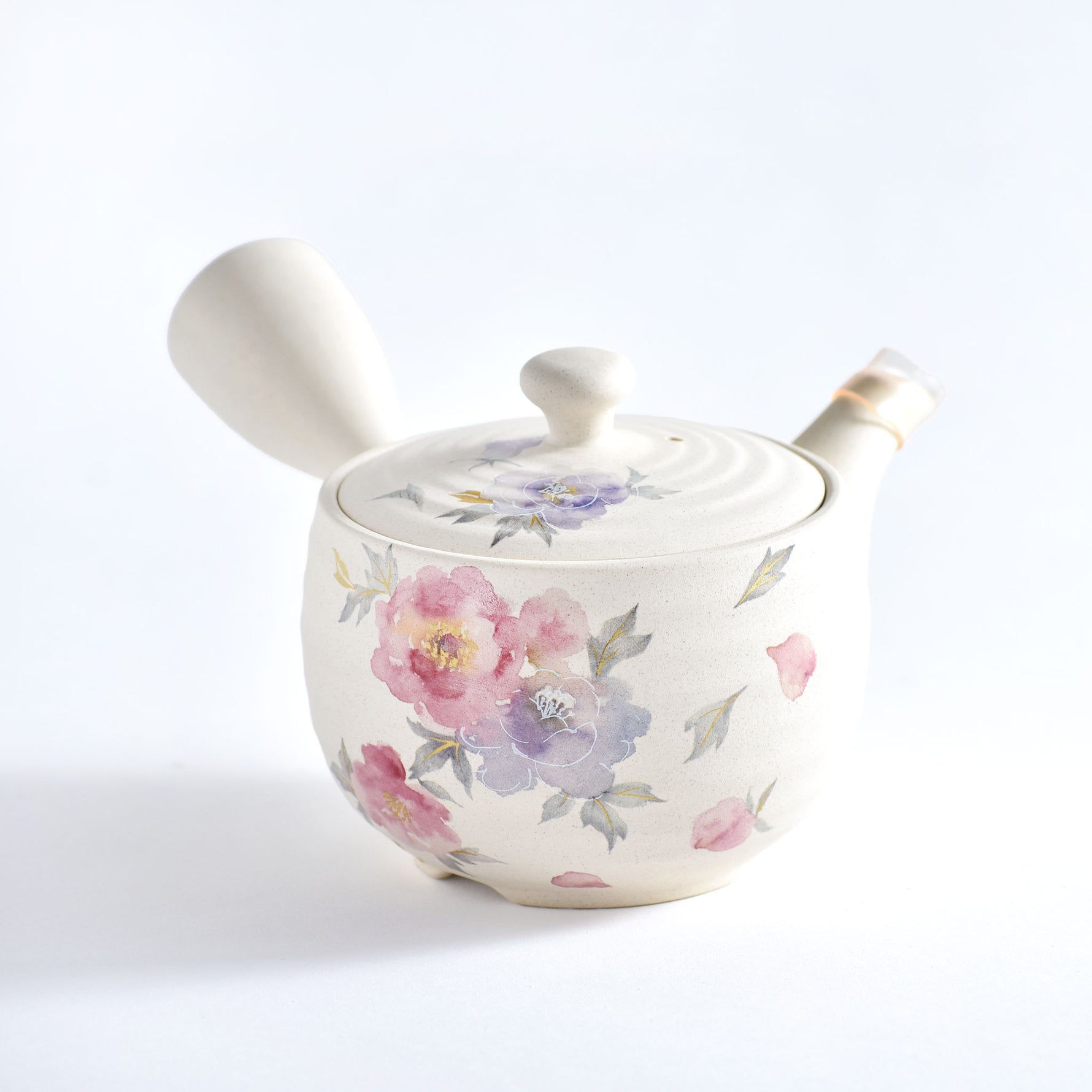 Ceramic teapot with floral design on a white background