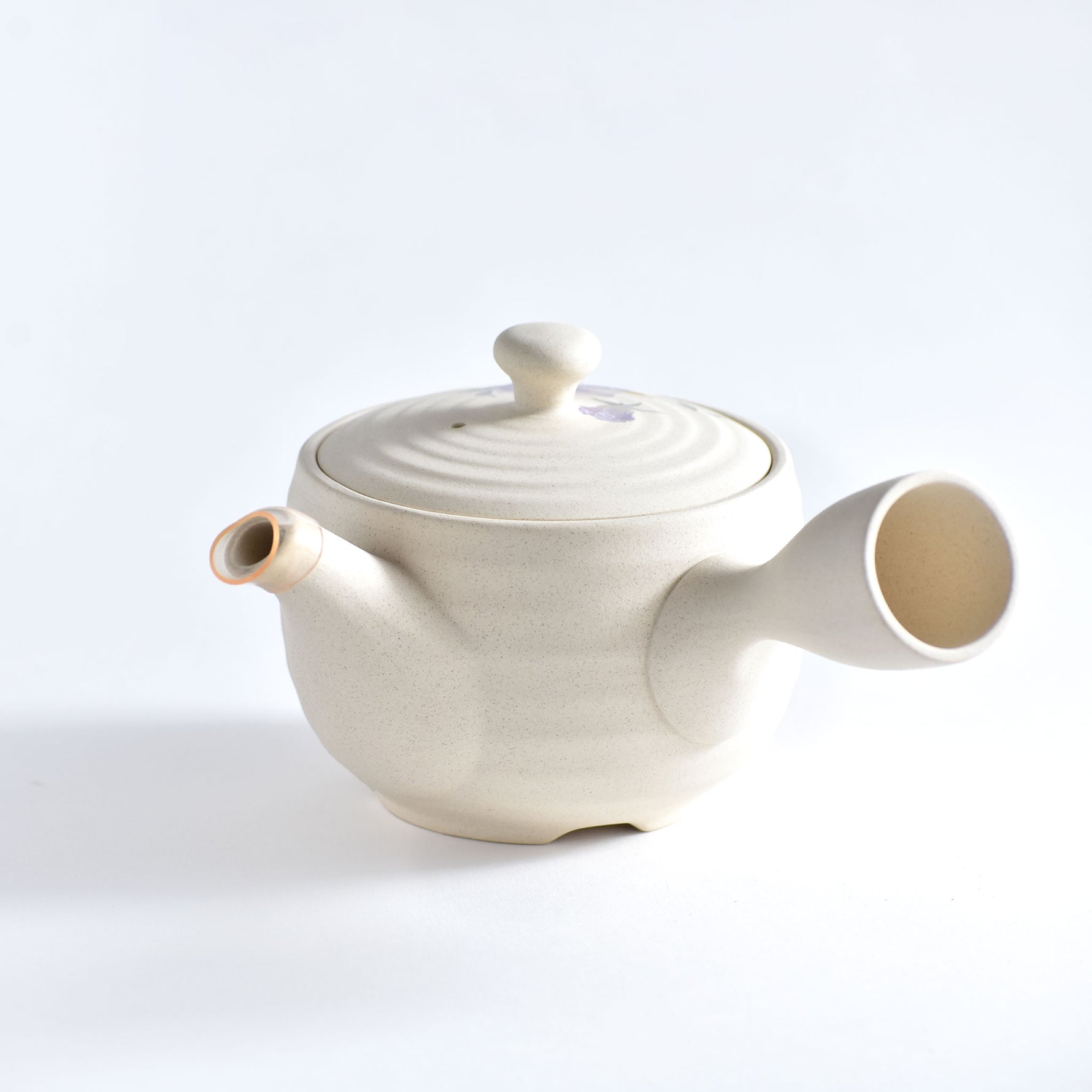White ceramic teapot on a light gray background