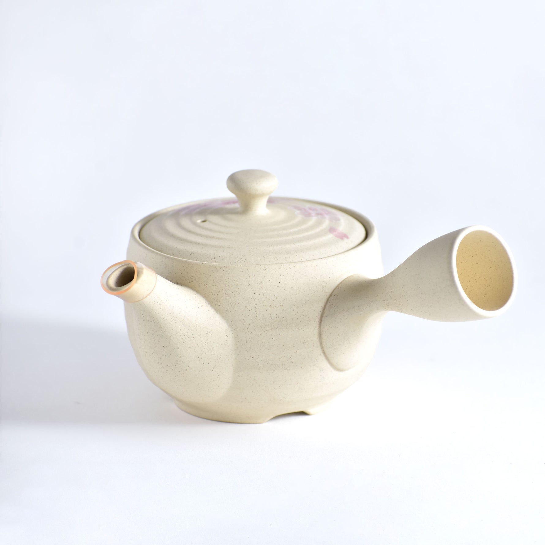 Cream-colored ceramic teapot on a white background