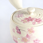 Ceramic teapot with pink floral design on a white background