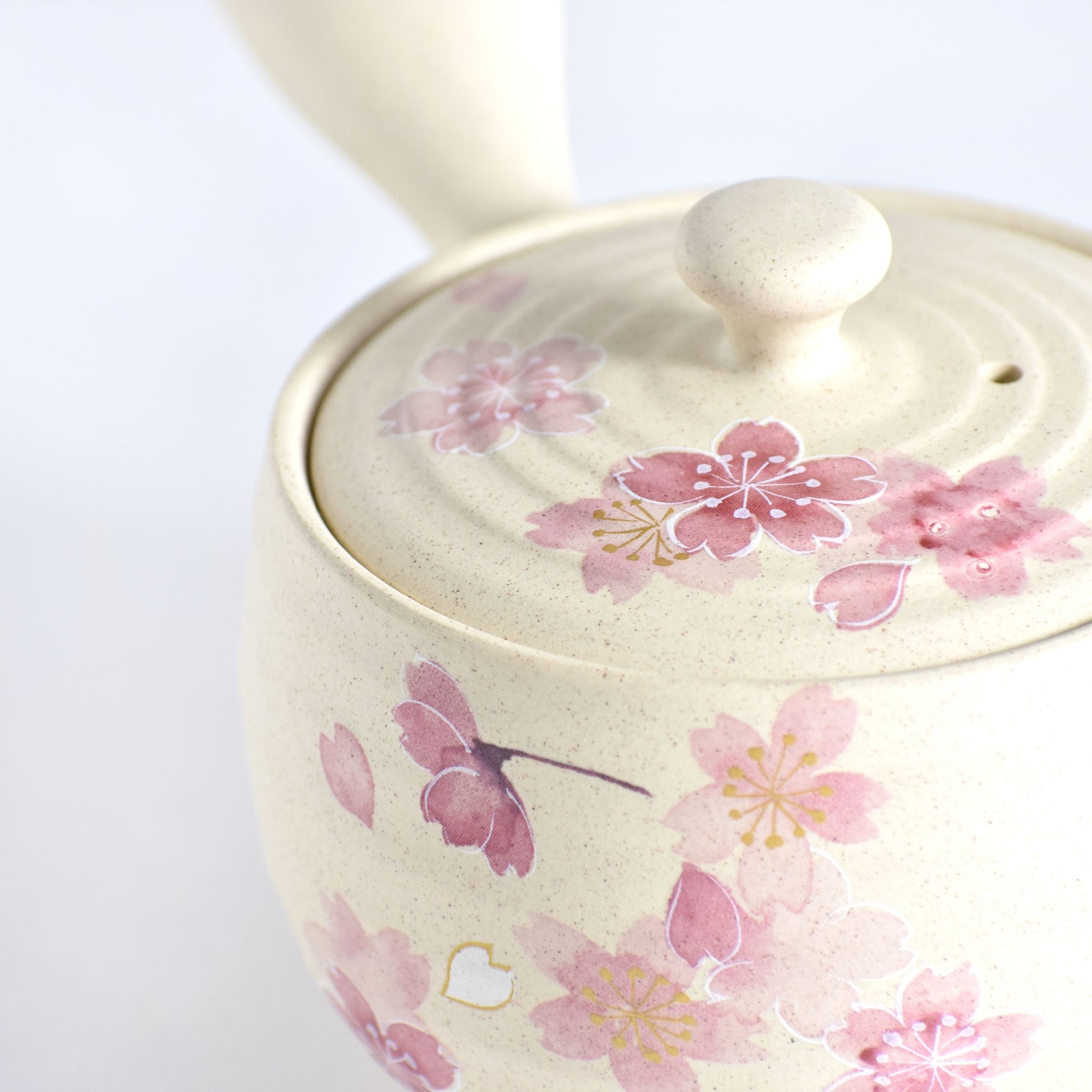 Ceramic teapot with pink floral design on a white background