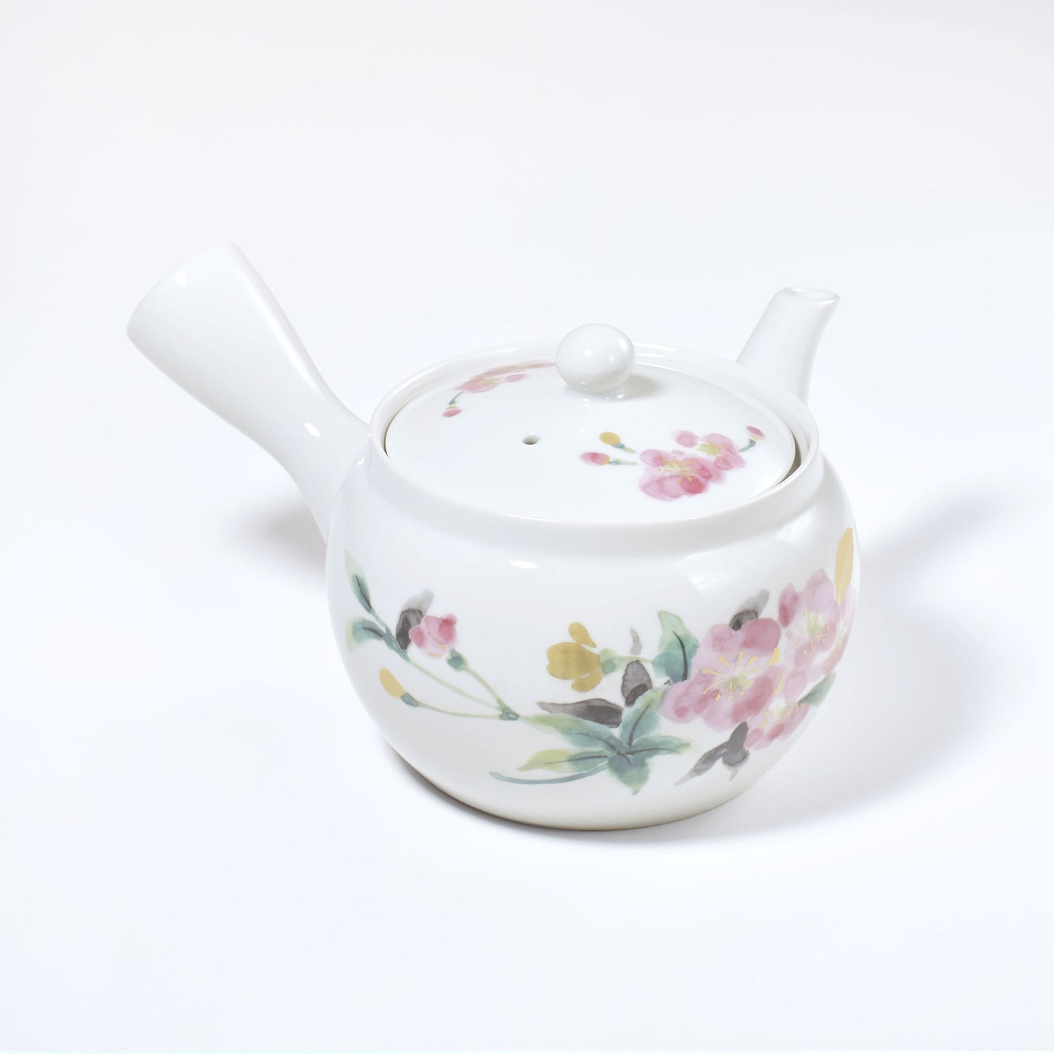 White ceramic teapot with floral designs on a white background