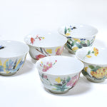 Set of ceramic cups with floral designs on a white background