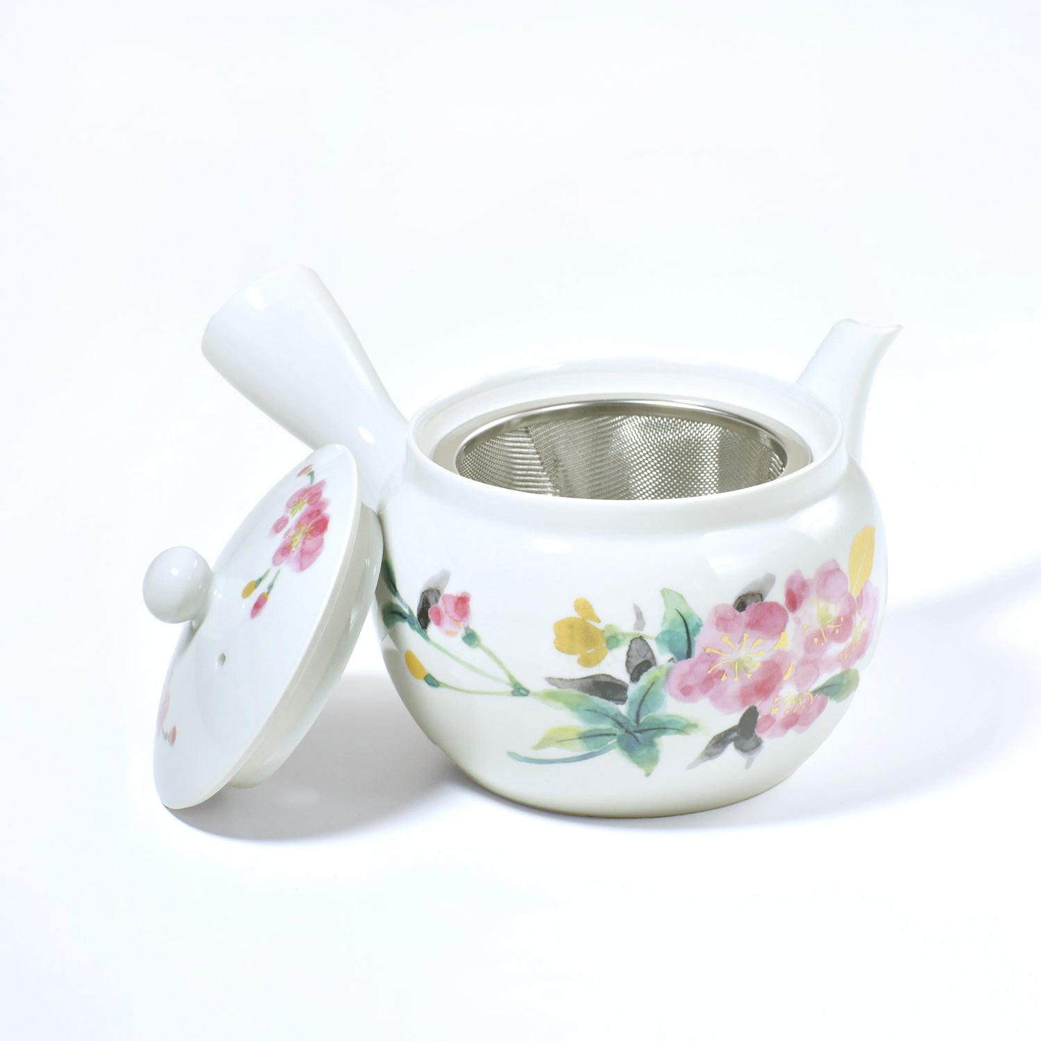 White ceramic teapot with floral designs on a white background