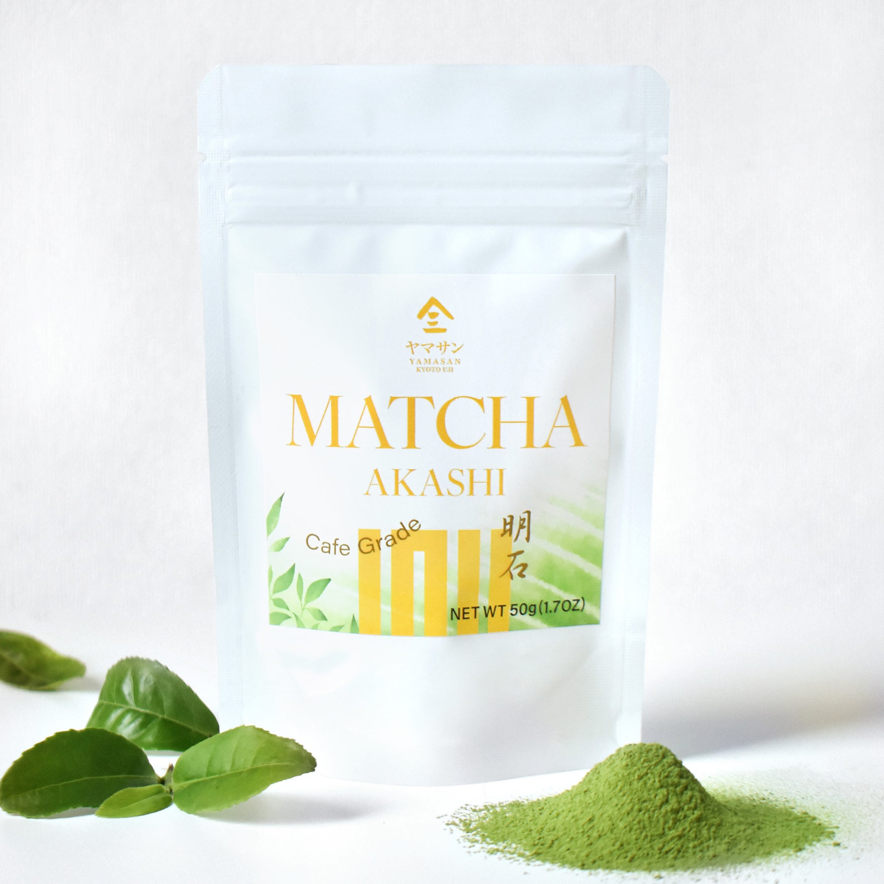 Matcha Akashi packaging with green leaves and matcha powder on a white background