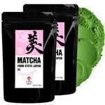 Two black packages of matcha green tea powder with a pink label on a white background.