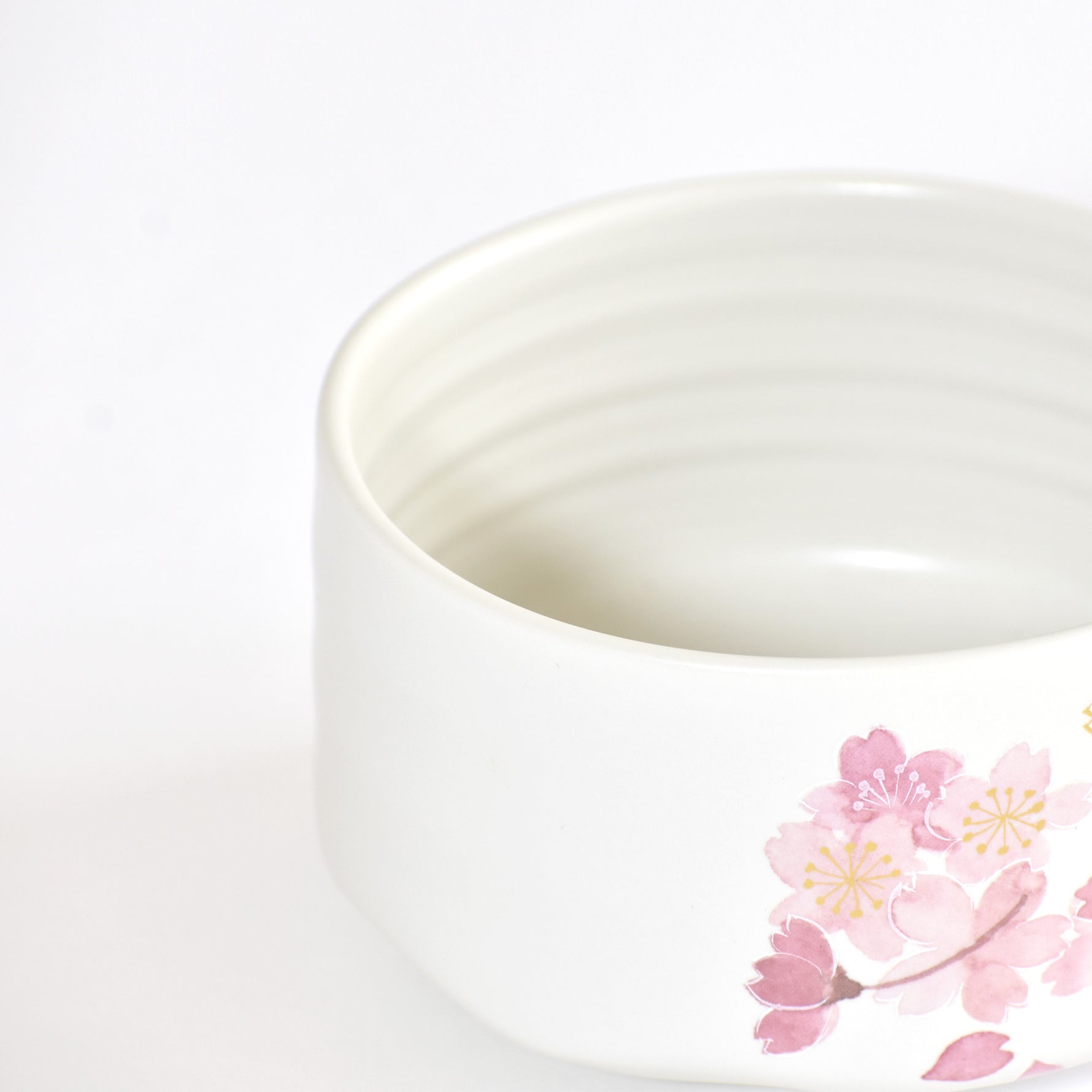White ceramic bowl with pink floral design on a white background