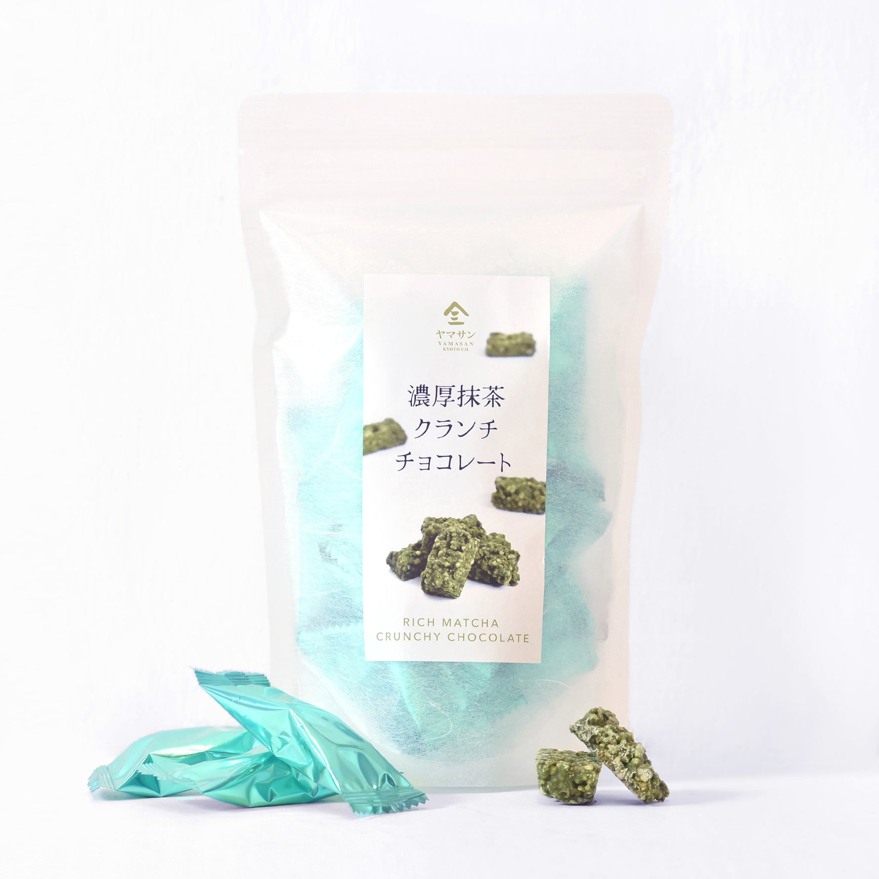 Packaged crunch chocolate with green crumbles on a white background