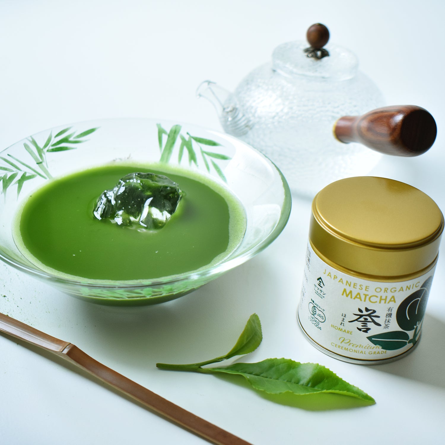 Matcha green tea in a bowl with a container of Japanese organic matcha on a white background