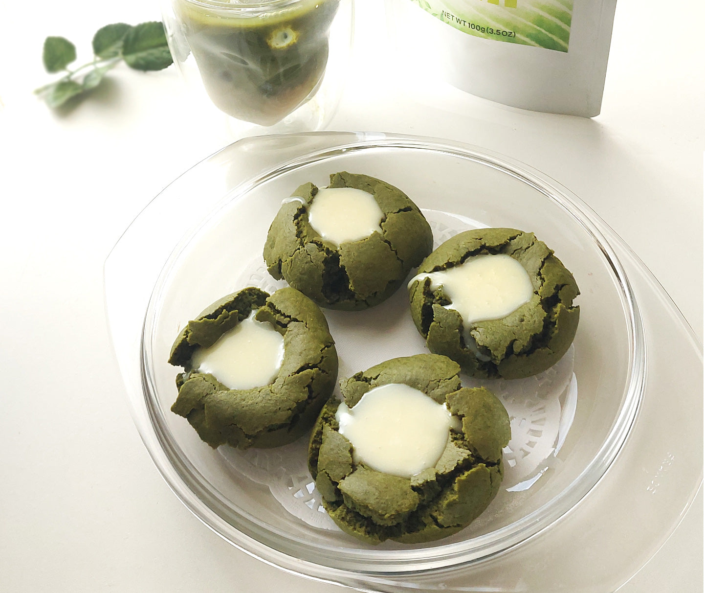 Green cookies with white centers on a clear plate, with a blurred background