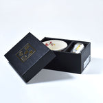 Matcha bowl and bamboo whisk set in a black gift box on a light gray background