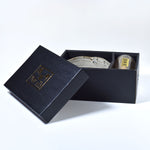 Gray ceramic matcha bowl and bamboo whisk set in a box on a white background