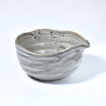 Gray ceramic matcha bowl with a unique texture on a white background