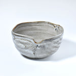 Gray ceramic matcha bowl with a unique texture on a white background