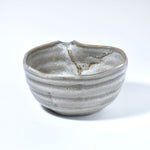 Gray ceramic matcha bowl with a unique texture on a white background