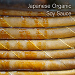 Stack of Japanese Organic Soy Sauce bottles with text overlay