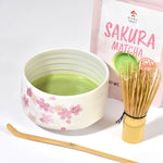Matcha green tea set with a bowl, whisk, and Sakura Matcha packaging on a white background