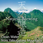 Mountain landscape with greenery and text about natural brewing and clean water from Yatsugatake Mountains.