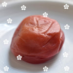 Japanese pickled plums (umeboshi) on a white plate with decorative flower patterns