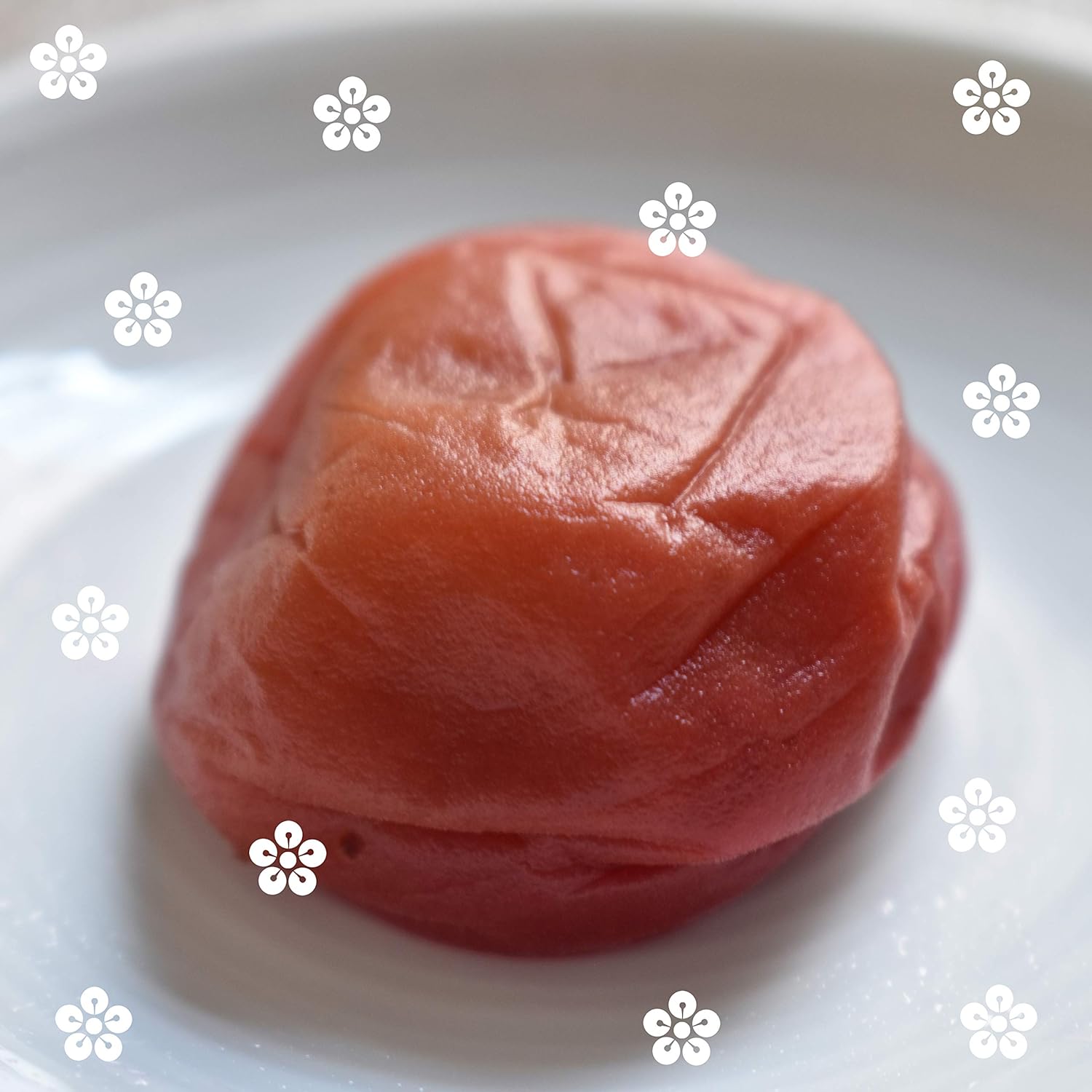 Japanese pickled plums (umeboshi) on a white plate with decorative flower patterns